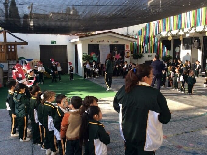 Alumnos y maestras reunidos en el patio del colegio durante un evento