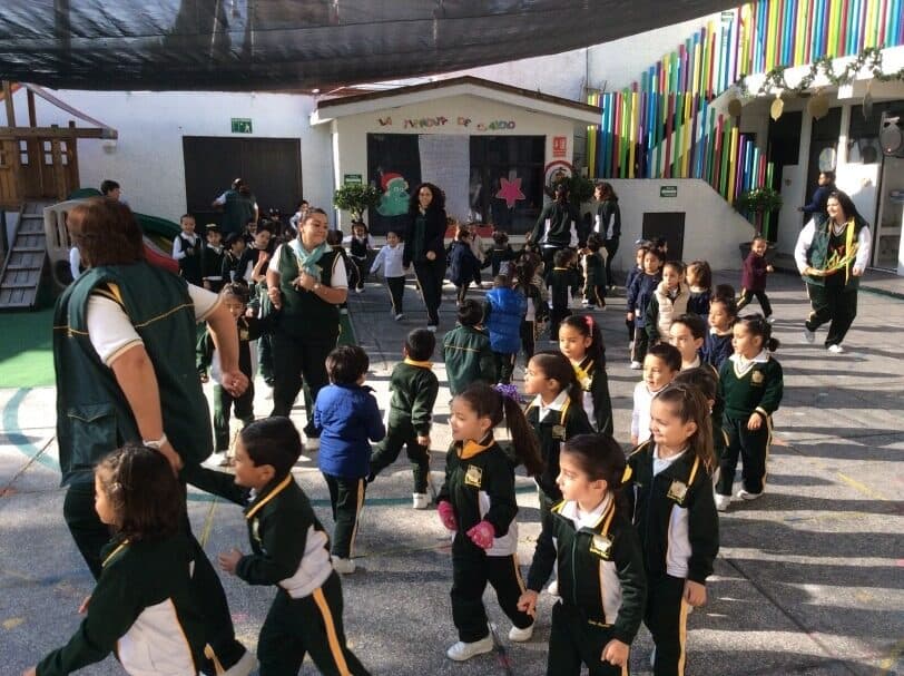 Grupo de alumnos y maestras durante una activación física en el patio