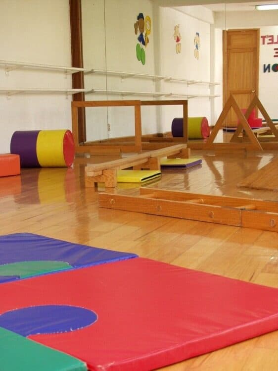 Salón de psicomotricidad con colchonetas, rampas de espuma y estructuras de madera